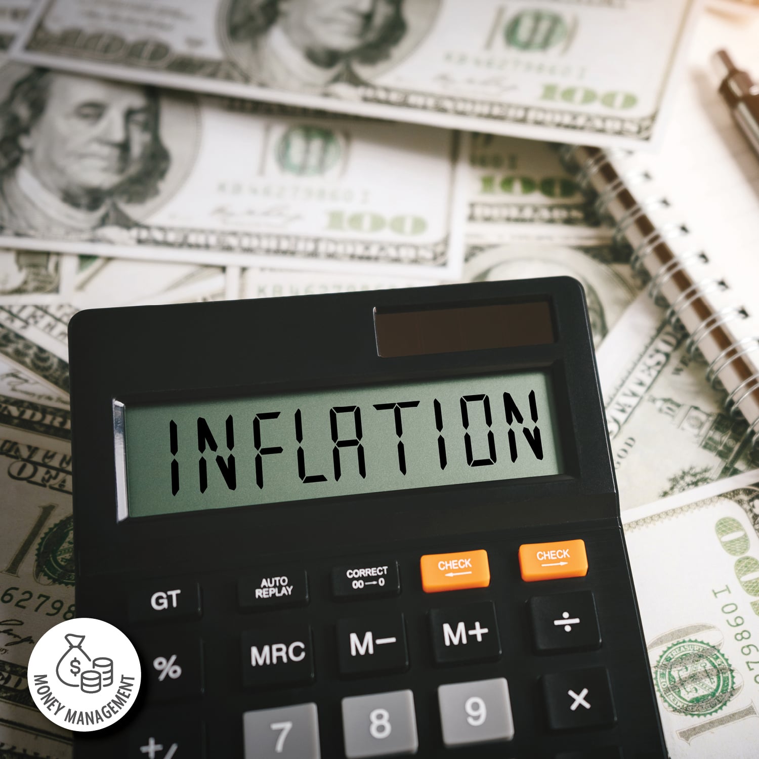 A calculator sits atop a pile of money with the words "inflation" on the display screen