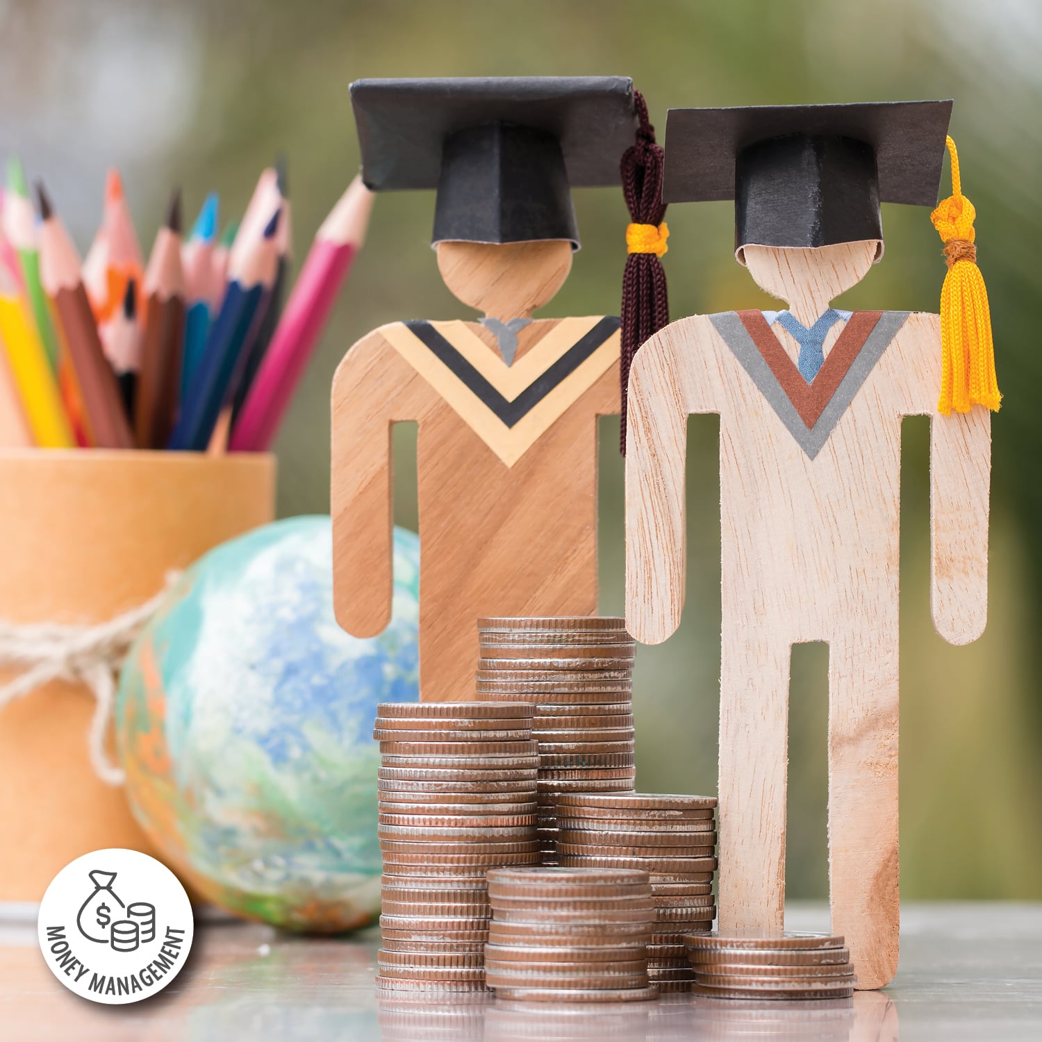 Two people shaped cut-outs made of wood wearing graduation caps are positioned next to stacks of coins.